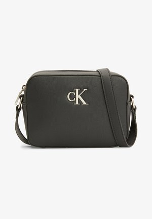 Sac bandoulière rectangulaire noir avec sangle ajustable, fermeture éclair argentée et logo « cK » argenté au centre devant.