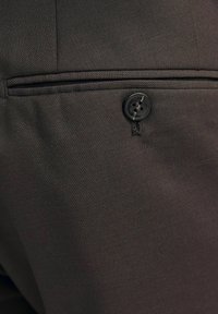 Dunkelbraune Hosen aus strukturiertem Stoff, mit einer Gesäßtasche, die mit einem schwarzen Knopfverschluss und dezenten Stickdetails versehen ist.