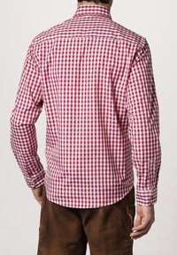 Rood-wit geruit overhemd met lange mouwen, een button-down kraag en manchetten, met een gebogen zoom en een subtiele textuur in de stof.