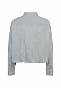 Camisa recortada en rayas verticales de color azul claro y blanco. Presenta un cuello puntiagudo, mangas largas y puños abotonados con un sutil detalle de metal.