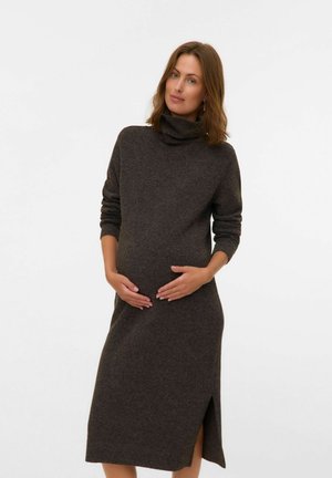 Robe de maternité en tricot marron avec un col haut, des manches longues et une fente sur le côté. Texture douce, ajustée au niveau de la taille, conçue pour le confort.