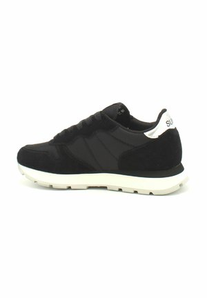 Sneaker sportivo nero con tomaia in camoscio e rete, suola in gomma bianca e accentuazione argentata sul tallone. Presenta una chiusura classica con lacci e punta rinforzata.