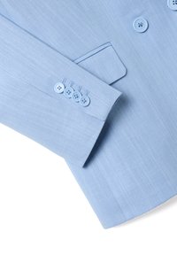 Manica di un blazer azzurro chiaro con tessuto testurizzato, quattro bottoni coordinati e un discreto dettaglio della tasca.