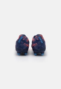 Botas de fútbol en azul oscuro y rojo con un upper texturizado, que presenta un patrón dinámico, acentos en azul y tachuelas moldeadas en la suela.