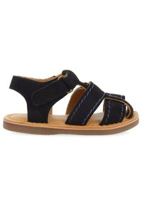 Black suede sandal with elastic straps and a tan rubber sole. Features blue stitching on straps and an adjustable hook-and-loop closure.