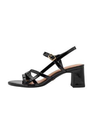 Sandales à talons en cuir verni noir avec design à lanières, bout carré, talon bloc, et boucle dorée en accent sur la bride ajustable à la cheville.