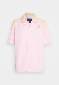 Chemise à manches courtes avec un corps rose, un col jaune et des accents de manches jaunes, ornée des initiales "MJ" brodées en fil sombre sur la poitrine.