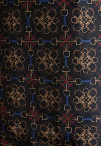 Melnā auduma, kurā ir simetriska zelta un zilo ģeometrisko formu raksts, starp kurām ir sarkanie akcenti un sarežģījumi.