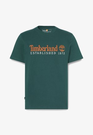 T-shirt in cotone verde con testo ricamato arancione sul davanti "Timberland ESTABLISHED 1973" e un piccolo logo sul lato. Design con colletto rotondo.