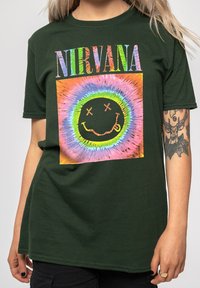 Green cotton t-shirt featuring a colorful Nirvana logo and smiley face graphic. Short sleeves with a relaxed fit and crew neckline.