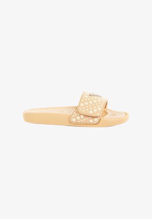 Beige Slide-Sandale mit verstellbarem Riemen, verziert mit kleinen und großen perlenähnlichen Perlen, flacher Sohle und strukturiertem Fußbett.