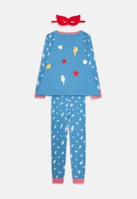 Pijamas de niño de manga larga azul con estrellas rojas y blancas y relámpagos amarillos, pantalones a juego y una máscara de superhéroe de tela roja.