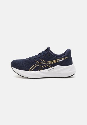 Sapatilha desportiva azul-marinho com um upper em malha texturizada, detalhes em dourado, uma entressola branca acolchoada rotulada como "Amplifoam+" e uma sola de borracha preta.