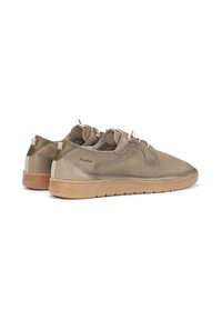 Zapatillas deportivas de color marrón claro con parte superior de malla perforada, suela de goma, cordones contrastantes y marca en el lateral.