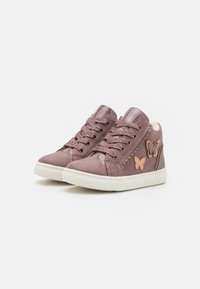 Roze suede sneakers met glanzende lakaccenten, gestructureerde veters en vlinderapplicaties. Voorzien van een witte rubberen zool.