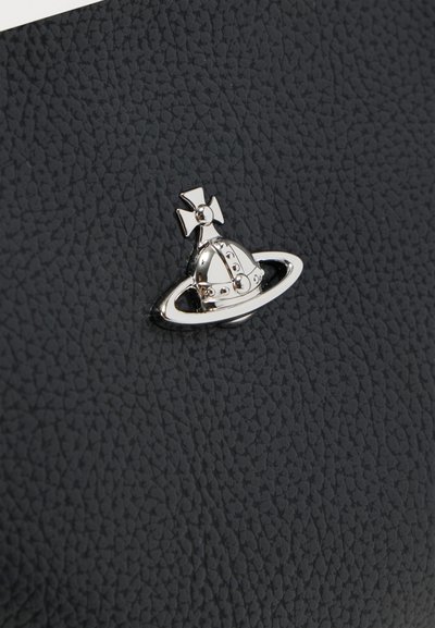 Μαύρο υφή δέρματος με ασημένια διακοσμητική καρφίτσα που απεικονίζει ένα κράνος και σταυρό μέσα σε κυκλικό πλαίσιο.