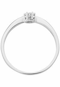 Anello in oro bianco con una fascia liscia e una semplice montatura rialzata con tre piccole gemme rotonde al centro.