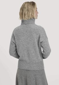 Grauer Strickpullover mit einem gerippten Kragen und Bündchen. Er hat eine lässige Passform und ein leicht verkürztes Design, hergestellt aus weichem Material.