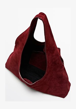 Borsa a spalla in suede rosso con una texture morbida, grande apertura superiore e una tasca interna nera per la conservazione. Manici rotondi per un facile trasporto.