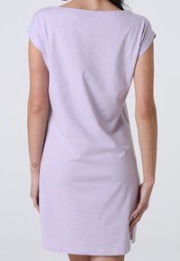 Abito corto a maniche corte color lillà con scollatura rotonda, vestibilità comoda e spacchi laterali. Realizzato in morbido cotone, presenta una texture liscia.