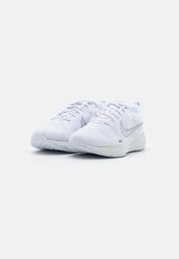 Scarpe da ginnastica bianche dal design elegante, con un materiale superiore traspirante, superficie texturizzata e una suola curva e imbottita.