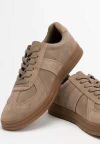 Braune Wildleder-Sneaker mit Schnürverschluss, Gummisohlen und glatter Textur. Verfügt über ein Seitenpanel und einen gepolsterten Kragen für zusätzlichen Komfort.