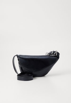 Czarna skórzana torba na ramię z zakrzywioną klapką, srebrnym elementem z klamrą oraz regulowanym paskiem na jednolitym białym tle.