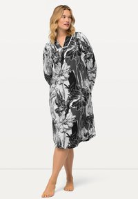 Vestaglia floreale in bianco e nero con scollatura a V, maniche lunghe e vestibilità ampia, realizzata in un morbido tessuto leggero.