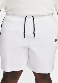 Baltas kokvilnas šortus maisījums ar elastīgu jostasvietu un melniem aukliņām. Raksturīga neliela melna Nike logo apakšējā kreisajā pusē.