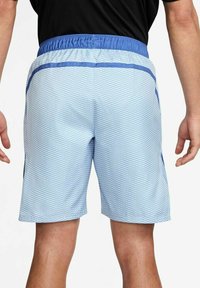 Shorts bleu clair à motifs en matériau synthétique, dotés d'une taille élastique et de accents bleus sur les côtés.
