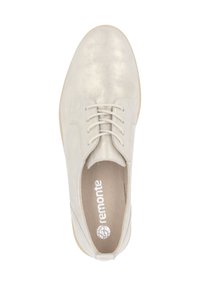 Chaussure beige clair à lacets avec une finition métallique lisse et un bout arrondi. Doublure intérieure douce avec une semelle légèrement flexible.