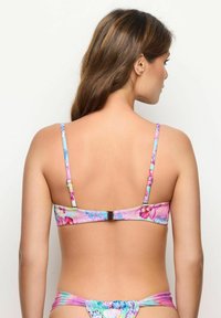 Costum de baie floral în culori pastelate, cu bretele subțiri și ajustabile, închidere cu clemă la spate și detalii cu volane pe partea de jos.