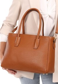 Bruine gestructureerde leren handtas met dubbele bovenhandvaten, een rechthoekige vorm, en een verstelbare schouderband.