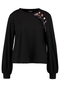 Svart långärmad topp med lös passform. Har en rutmönstrad volangdetalj på ena axeln, prydd med dekorativa knappar. Mjuk tygkänsla.