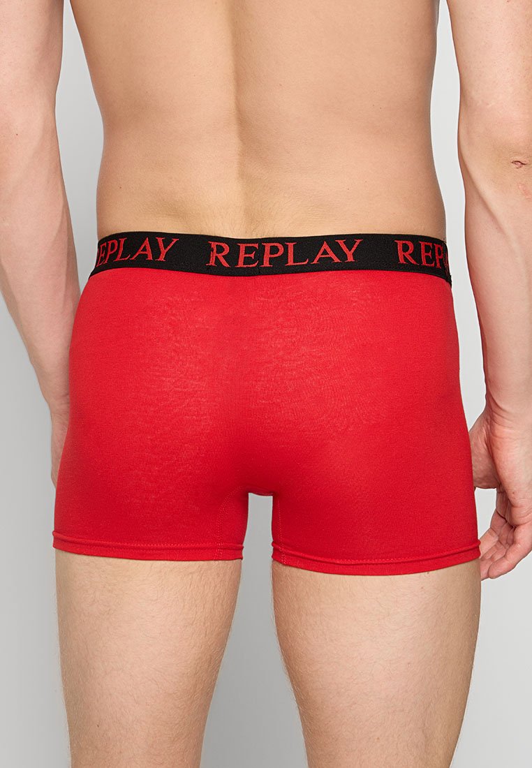 Rote Baumwollboxershorts mit einem schwarzen elastischen Bund, auf dem der Markenname "REPLAY" in Rot gedruckt ist. Glatte Textur und körpernahe Passform.