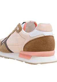Sneaker met een beige suede bovenzijde, lichtroze leren accenten en witte mesh details. Grijze en koraalkleurige zool met branding aan de zijkant.