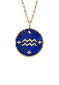 Pendente in lapislazzuli con accenti dorati, caratterizzato da un motivo a zigzag e motivi a stella, sospeso a una catena d'oro. Forma rotonda, colore blu intenso.
