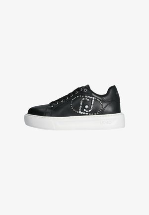 Sneaker in pelle nera con suola in gomma bianca, caratterizzato da borchie decorative argentate disposte in un motivo circolare sul lato. Etichettato "LIU JO."