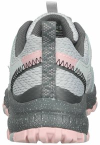 Zapatilla deportiva gris y rosa claro con parte superior de malla, mediasuela gris texturizada y un bucle en el talón. Cuenta con una suela exterior moteada.
