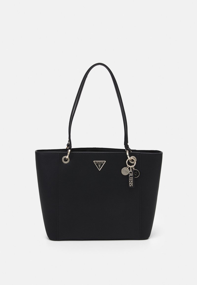 Sac cabas Guess en cuir noir avec double poignée, plaque logo triangulaire et porte-clés métallique de la marque sur un fond uni.