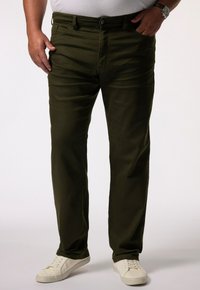 Pantalones de algodón verde oliva con corte recto, diseño de cinco bolsillos, cierre de botón y combinados con zapatillas blancas sobre un fondo claro.
