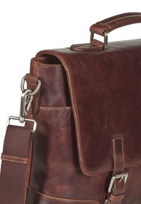 Sac en cuir marron à bandoulière avec un rabat, des éléments en métal et une bandoulière amovible. Présente une surface texturée et des coutures minimales.