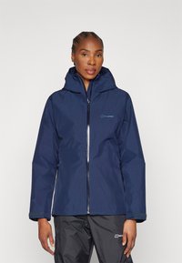 Navy waterproof jacket with a hood and zip closure. Features elastic cuffs and branded logo on the chest. Smooth texture and sleek design.