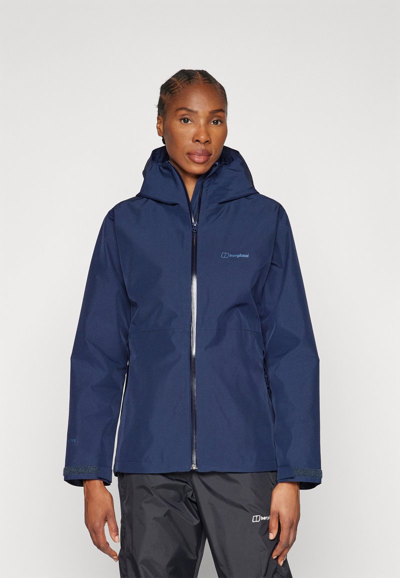Navy waterproof jacket with a hood and zip closure. Features elastic cuffs and branded logo on the chest. Smooth texture and sleek design.