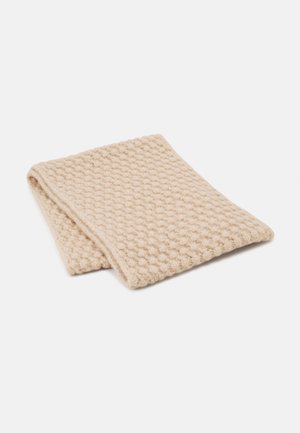 Écharpe en maille beige pliée avec un motif texturé en forme de bulles sur un fond blanc uni.