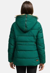 Green puffer jacket with a fur-lined hood, quilted texture, adjustable cuffs, and a branded tag on the lower back.