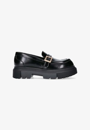 Zwarte gepatineerde leren instapper met een chunky zool, voorzien van een decoratieve gespdetail. Gladde afwerking met een verhoogde rand en een gestructureerde zool.
