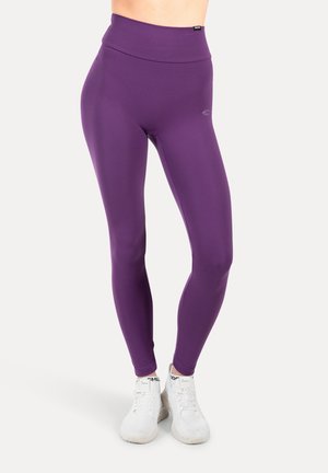 Högmidjade lila leggings i mjukt, elastiskt tyg med en slät yta och en subtil logotyp nära midjan.