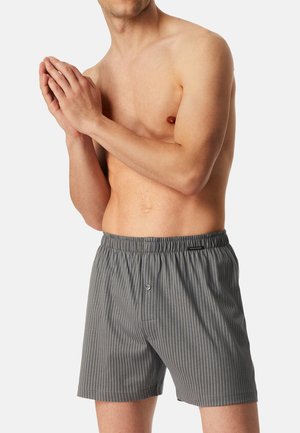 Grau gestreifte Boxershorts mit einem elastischen Bund und einem Knopfverschluss. Der Stoff wirkt leicht und hat eine glatte Textur.