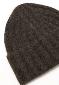 Beanie in lana marrone scuro lavorato a maglia con una texture a coste. Il tessuto appare morbido e leggermente peloso, formando una forma rilassata nella parte superiore.